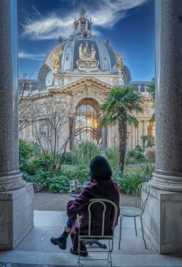 Paris, France - 12 26 2024: Le Petit Palais. View of a woman sitted in the semicircular peristyle of the courtyard, decorated with Tuscan-style columns and bas-reliefs clipart