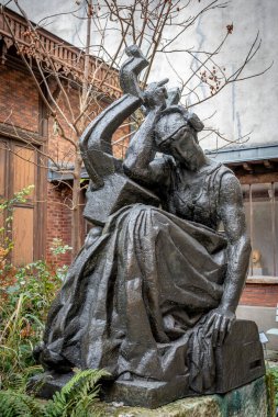 Paris, Fransa - 12 14 2024 Bourdelle Müzesi. Sonbaharda kapalı bahçedeki anıtsal bronz heykel, Sappho ve kırmızı tuğla binaların manzarası