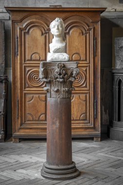 Paris, Fransa - 12 14 2024 Bourdelle Müzesi. Heykeltraşın atölyesinin içinde bir adamın kafasının heykeli ve ahşap bir dolap var.