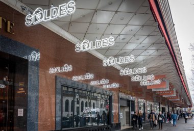 Paris, Fransa - 01 11 2025: Satış sırasında Büyük Mağaza Galerisi-Lafayette 'in pencerelerinin önündeki kış satışları için aydınlatılmış tabelalar