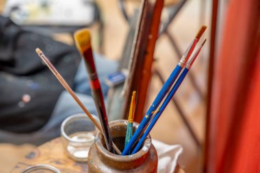 Bir konteynırdaki boya fırçaları resim dersi sırasında tabureye yerleştirilir.