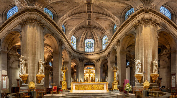 Paris, France - 12 14 2024: Saint-Sulpice Church. Panoramic view of the nave, the altar, ceiling, columns, statues, wooden chairs and stained glass window