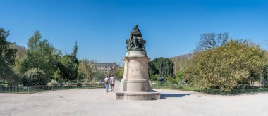 Paris, Fransa - 04 05 2025: Jardin des Plantes. Botanik bahçesinin panoramik manzarası, Lamarc heykeli ve arkasındaki Büyük Evrim Galerisi.