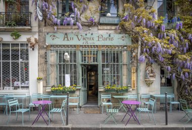 Paris, Fransa - 04: 12 2025: Au Vieux Paris d 'Arcole. Çiçek açmış bir salkım ağacı olan tipik bir Paris restoranı manzarası
