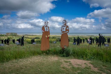 Vers-Sur-Mer, Fransa - 05 16 2025: British Normandy Memorial. The Standing with Giants 'ın panoramik görüntüsü. İki hemşire silueti var.