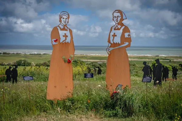 Vers-Sur-Mer, Fransa - 05 16 2025: British Normandy Memorial. The Standing with Giants 'ın panoramik görüntüsü. İki hemşire silueti var.