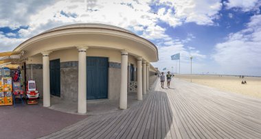 Deauville, Fransa - 05: 17 2025 Deauville Plajı. Sahilin panoramik manzarası Deauville tahtaları, kum, deniz ve bulutlu mavi gökyüzü