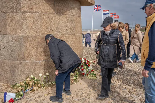 Omaha Sahili, Fransa - 05: 15 2025 Sinyal Anıtı. Amerikalı turistler, çiçekler ve bayraklarla The Braves 'in anısına yapılan törenin manzarası