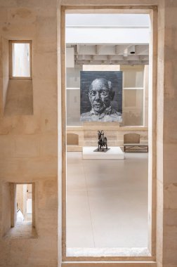 Paris, Fransa - 06 14 2025: Ulusal Picasso Müzesi. Yan Pei-Ming 'in yaptığı Picasso' nun Portresi ve Hotel Sale 'in giriş salonunda palmiye yaprağı, metal ve alçıdan yapılmış Keçi heykeli.