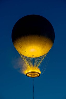 Paris, Fransa - 07 01 2025: Olimpiyat kazanının gece karanlığında mavi gökyüzü arka planında uçuşunun ayrıntılı görüntüsü