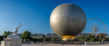 Paris, Fransa - 07 03 2025: Olimpiyat kazanın panoramik manzarası heykeller, dönme dolap ve Tuileries bahçesindeki turistlerle dolu büyük yuvarlak havzaya yerleştirildi