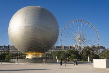 Paris, Fransa - 07 03 2025: Olimpiyat kazanın panoramik manzarası heykeller, dönme dolap ve Tuileries bahçesindeki turistlerle dolu büyük yuvarlak havzaya yerleştirildi
