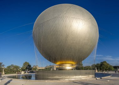 Paris, Fransa - 07 03 2025: Olimpiyat kazanının panoramik manzarası, Tuileries bahçesindeki turist ve heykellerle dolu büyük yuvarlak havzaya yerleştirildi