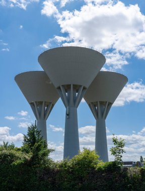 Alencon, Fransa - 07 08 2025: Panoramik manzara üç beyaz silindirik su kulesi ve arka planda bulutlu bir vlue gökyüzü