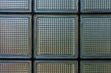 Bir evdeki cam tuğla pencerenin ve arkadaki bahçenin detaylı görüntüsü