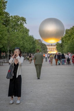Paris, Fransa - 07 03 2025: Genç bir Asyalı kadın Tuileries bahçesinde Olimpiyat kazanıyla selfie çekiyor