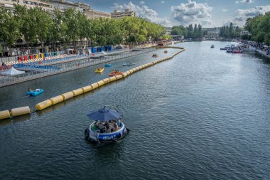 Paris, Fransa - 07: 19 2025: Paris Plajı, Bassin de la Villette. 10 kişi için tasarlanmış ve yelken açarken yemek pişirmek için merkezi bir ızgarayla donatılmış dairesel bir teknenin görüntüsü.
