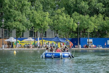 Paris, Fransa - 07: 19 2025: Paris Plajı, Bassin de la Villette. 10 kişi için tasarlanmış ve yelken açarken yemek pişirmek için merkezi bir ızgarayla donatılmış dairesel bir teknenin görüntüsü.