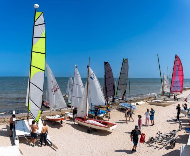 Saint-Aubin-Sur-Mer, Fransa - 08 10 2025: Sahilde renkli yelkenli tekneleri ve yelkenlileri görmek