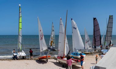 Saint-Aubin-Sur-Mer, Fransa - 08 10 2025: Sahilde renkli yelkenli tekneleri ve yelkenlileri görmek