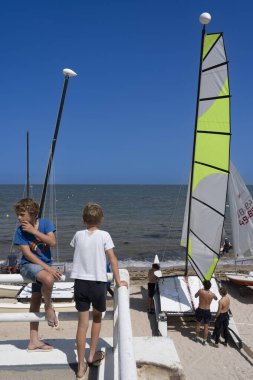 Saint-Aubin-Sur-Mer, Fransa - 08 10 2025: Sahilde renkli yelkenli tekneleri ve yelkenlileri görmek
