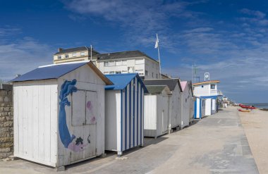 Langrune-Sur-Mer, Fransa - 08 07: 2025: Renkli çatıları olan panoramik plaj kabinleri, kurtarma merkezi ve sahil kıyısı boyunca mavi bulutlu bir gökyüzü