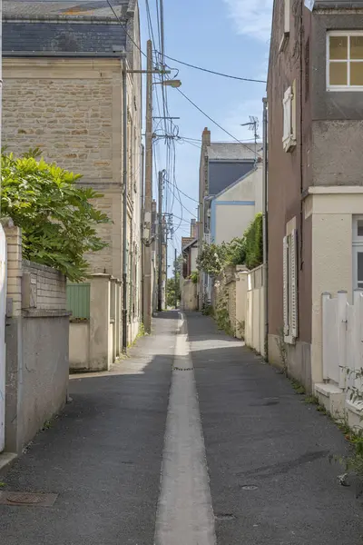 İskeleye ve sahile taş evlerin katıldığı dar bir geçit manzarası.