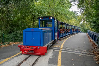 Gennevilliers, Fransa - 08: 30 2025: Parktaki tren istasyonunun yanındaki küçük mavi turist treni