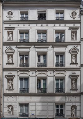 Paris, Fransa - 08: 23: 2025: Her katta heykeller olan bir Paris konut binasının cephesi