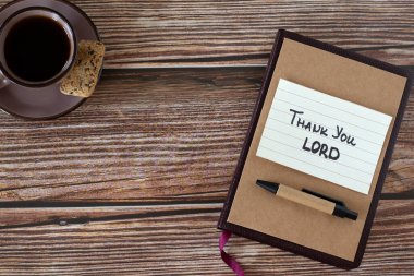 Teşekkür ederim, Tanrı 'nın el yazısıyla yazılmış bir metin, bir fincan kahve ve ahşap zemin üzerine kutsal İncil. Üst tablo görünümü, kopyalama alanı. Hristiyan kutsaması, minnettarlık, şükran günü ve Tanrı 'ya şükür..