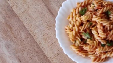 İtalyan makarnası, ev yapımı kırmızı domates sosu, peynir, maydanoz ve fesleğen ile servis edilen kadın elleri. Üst görünüm, yakın çekim.