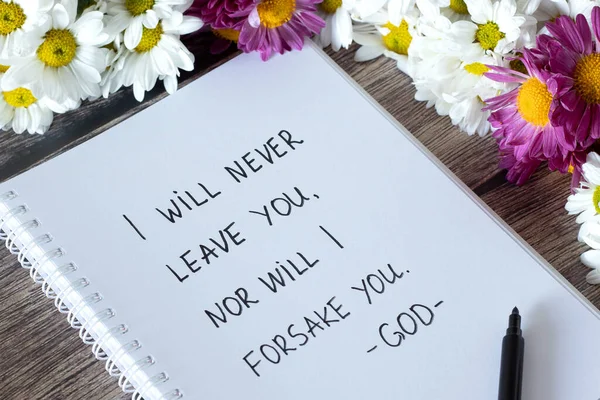 I will never leave you, nor will I forsake you, God. Encouraging Christian verse handwritten in notebook with flowers. Jesus Christ\'s promise, mercy, grace and love concept. Hebrews 13:5 text.