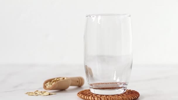 Ρίχνουμε Βιολογικό Σπιτικό Γάλα Βρώμης Ποτήρι Λευκό Φόντο Κοντινό Πλάνο — Αρχείο Βίντεο