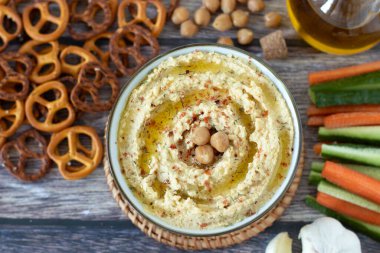 Taze sebzeli nohut sosu, zeytinyağı, sarımsak ve ahşap üzerine kraker. Üst masa manzaralı. Sağlıklı atıştırmalıklar.