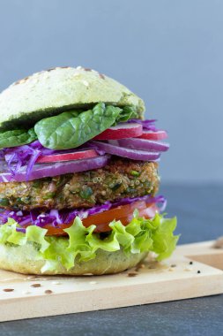 Marullu, domatesli, soğanlı, ıspanaklı ve kırmızı lahanalı vejetaryen sandviç. Yakın plan. Organik gıda, bitki temelli et alternatif konsepti.