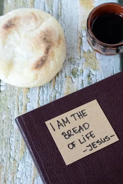 I am the bread of life - Jesus Christ, handwritten quote with holy bible book and cup of wine on wood. Christian Passover, spiritual food and drink, salvation from God, biblical concepts.
