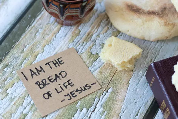 I am the bread of life - Jesus Christ, handwritten quote with holy bible book and cup of wine on wood. Spiritual food and drink, Christian biblical concept.