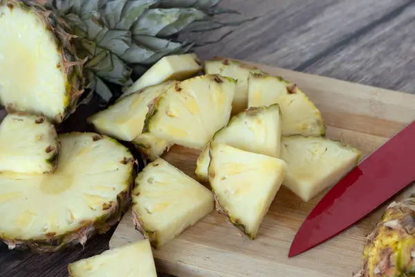 stock image Fresh pineapple (ananas) slices on wooden cutting board with knife. Bromelain food, healthy yellow tropical fruit chopped in pieces.