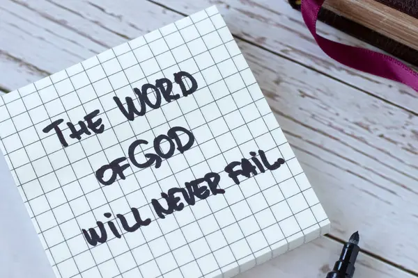 The Word of God will never fail, handwritten quote with holy bible on wood. Close-up. Inspiring Christian message about Jesus Christ\'s faithful promise, purpose, and plan. Biblical concept.