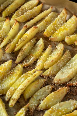 Kızarmış patates kızartması. Baharat ve susam tohumuyla tatlandırılmış. Yakın plan. Seçici odak.