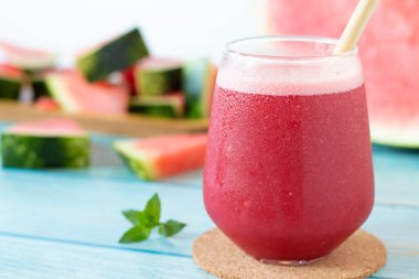 Ahşap masada naneli karpuz smoothie bardağı. Yakın plan. Soğuk kırmızı yaz içeceği, sağlıklı meyve suyu..