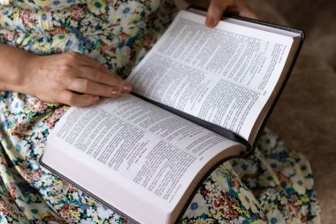 Kıdemli Hristiyan kadın kutsal kitaptan ilahiler okuyor ve okuyor. Yakın plan. Seçici odaklanma. İncil 'deki bilgelik, inanç ve Tanrı' ya itaat kavramı..