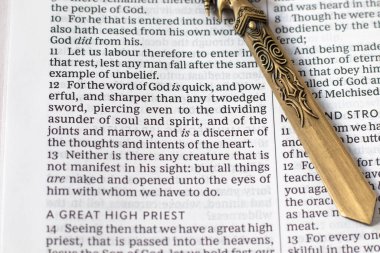 Kutsal kitap sayfasında antik bir kılıç. Yakın plan. İncil 'de geçen Hıristiyan ruhani güç kavramı, Tanrı' nın kelimesi İsa Mesih. Seçici odak.