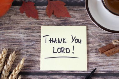 Teşekkürler Tanrım, ahşap masanın üzerine el yazısıyla yazılmış bir not kahve fincanı, buğday ve sonbahar yaprakları. Üst Manzara. Hristiyan şükran günü, şükran ve şükran duaları, İncil 'deki kavram İsa Mesih' e..