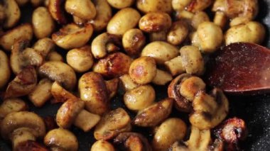 Kızartma tavasında yağlı mantar pişirme şampiyonu. Yakın plan. Sağlıklı ev yapımı yiyeceklerin hazırlanması.