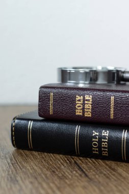 Kutsal İncil kitapları, beyaz arkaplan ve ahşap masa üzerinde büyüteç. Yakın plan. Uzayı kopyala Hıristiyan eğitimi, eğitim ve okuma, İncil kavramı.