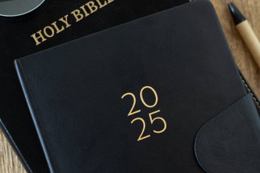 2025 takvim defteri ve kutsal kitap. Yakın plan. Üst Manzara. Hıristiyan eğitimi, öğrenme, adanmışlık, kutsal kitap eğitimi, İncil kavramı.