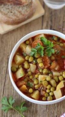 Tahta masada patates ve sebzeli ev yapımı vegan güveç. Dikey video. Üst Manzara. Sağlıklı etsiz yemek..