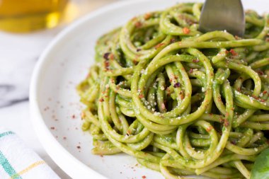 Çatallı, ıspanaklı makarna soslu yeşil spagetti. Yakın plan. Seçici odaklanma. Sağlıklı ev yapımı vejetaryen yemekleri yemek..