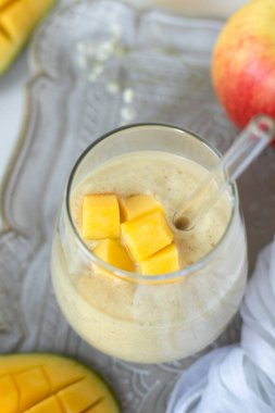 Kırsal masada bir bardakta mangolu smoothie. Üst Manzara. Ev yapımı, tropik meyveli bir içecek..